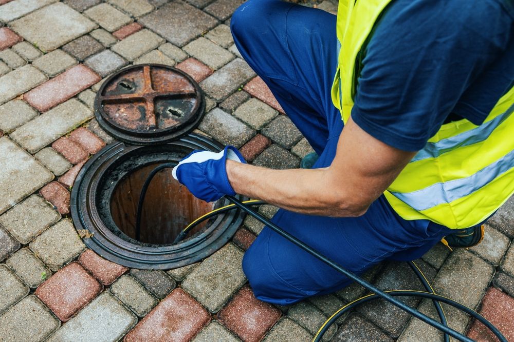 service worker cleaning blocked sewer line with hydro jetting