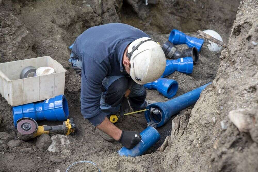 Workers,Install,Underground,Pipes,For,Water,,Sewerage,,Electricity,And,Fiber